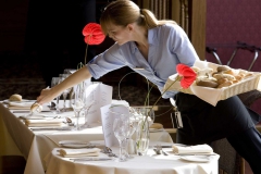 A waitress setting a table in the <a href="https://www.kingsmillshotel.com/dining/conservatory-restaurant/">Conservatory Restaurant</a>