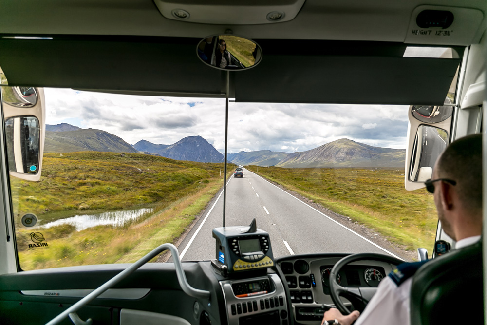 View of Scottish Highlands through front window of a bus