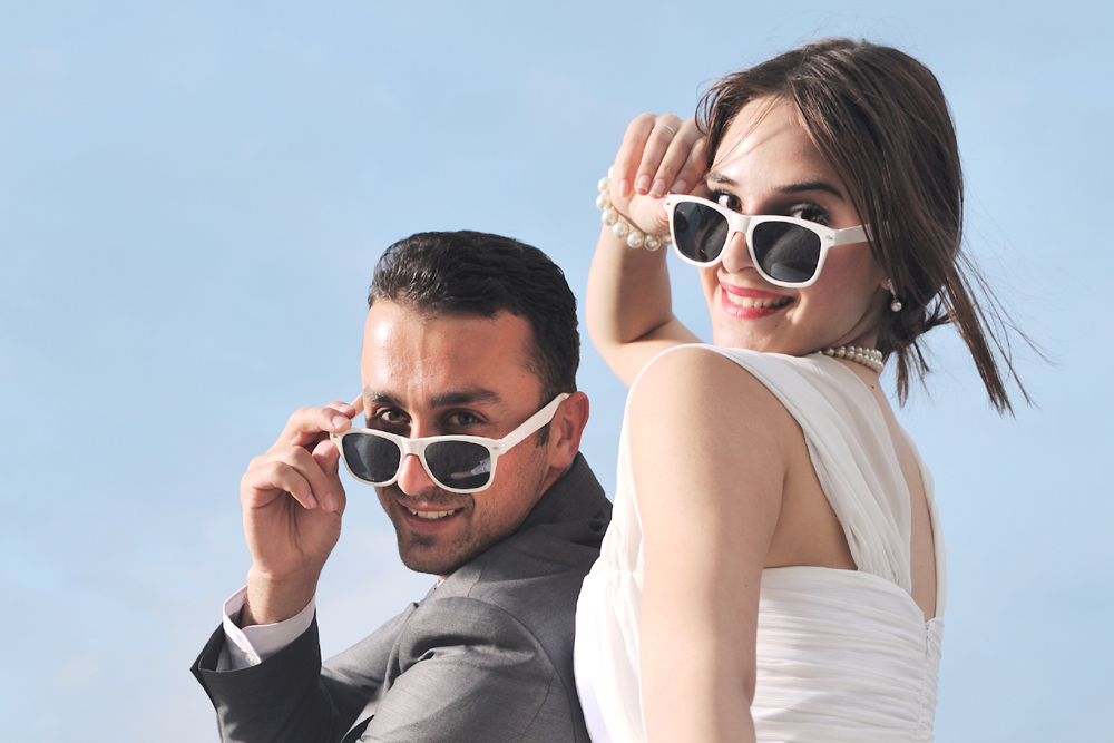 A bride and groom wearing sunglasses