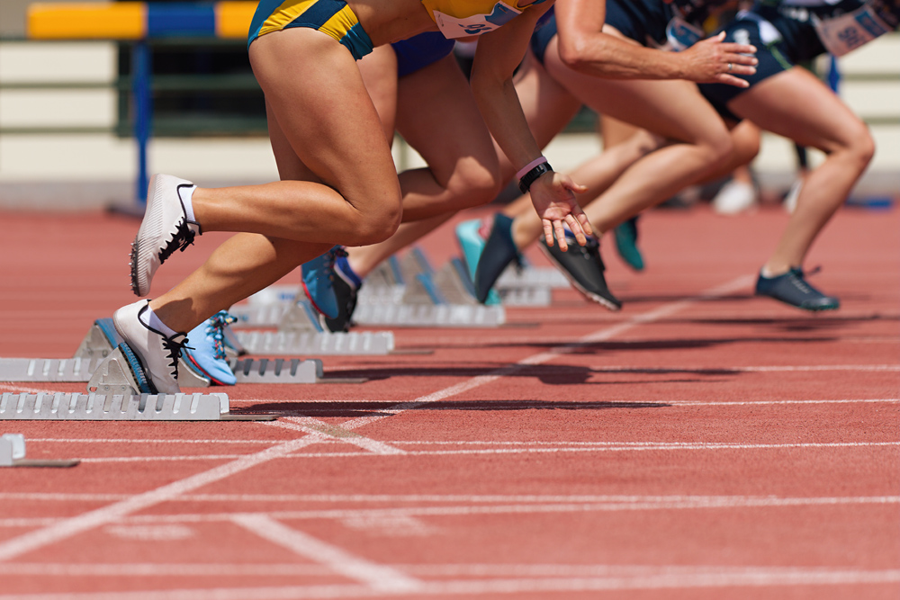 Group of female track runners on starting blocks