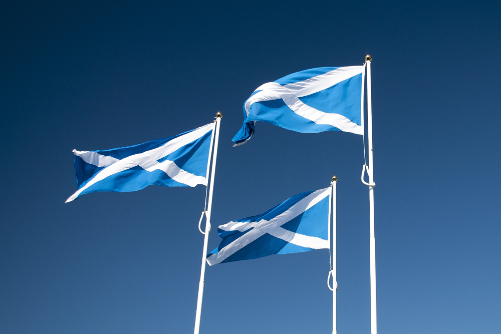 Three Scottish flags against a blue sky