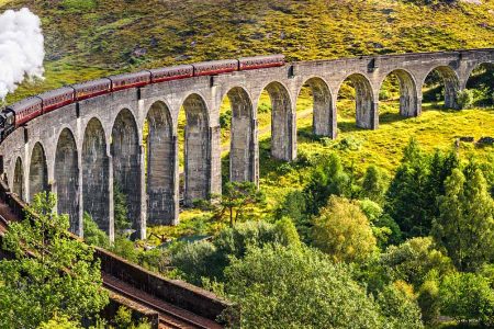 The Jacobite Steam Train travels over the Glenfinnan Viaduct in the Scottish Highlands