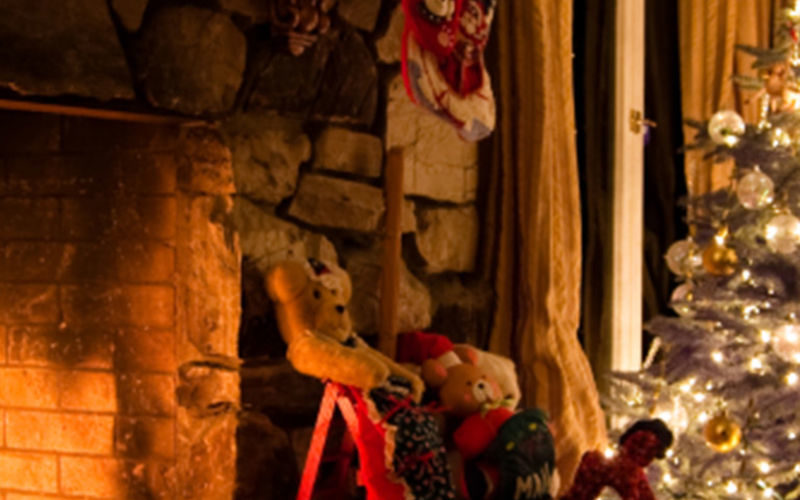 A roaring fire with a Christmas tree next to it