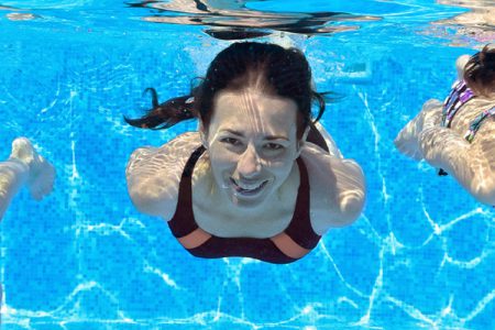 Children swimming under water in a pool