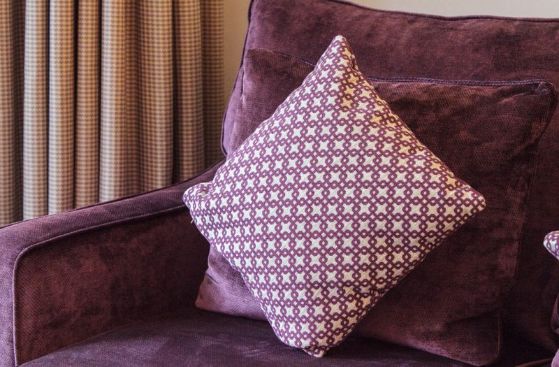A pillow on a comfy chair in a luxury Kingsmills Hotel room