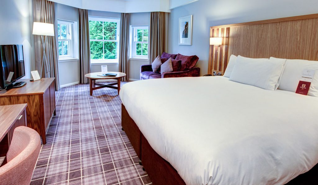 A bed and sofa in the living area at Kingsmills Hotel, Inverness