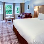 A bed and sofa in the living area at Kingsmills Hotel, Inverness