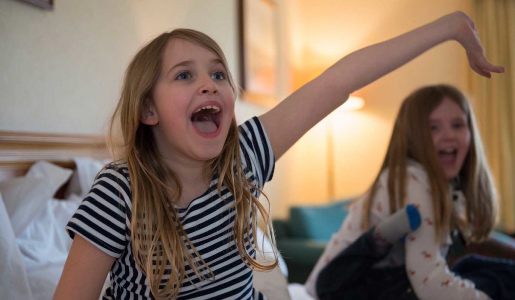 Children playing on a bed in a Retreat Family Room at Kingsmills Hotel