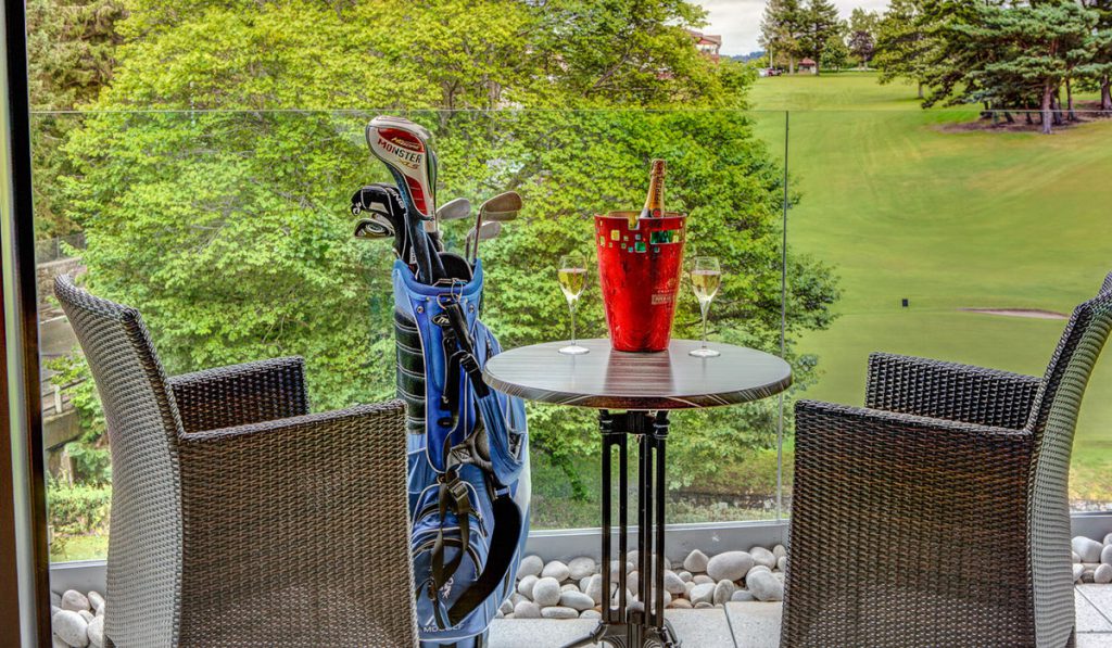 A balcony with a golf course in the background in a Retreat Room at Kingsmills Hotel
