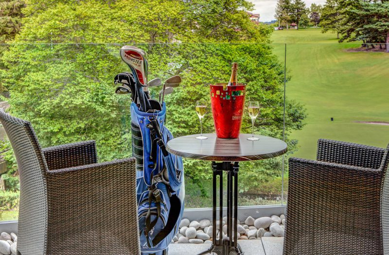 A balcony with a golf course in the background in a Retreat Room at Kingsmills Hotel