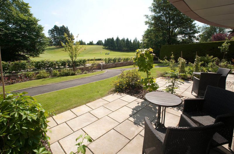 A patio and garden furniture outside a Retreat room at Kingsmills Hotel