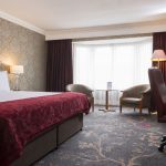 A large bed with bright, big windows at Kingsmills Hotel, Inverness