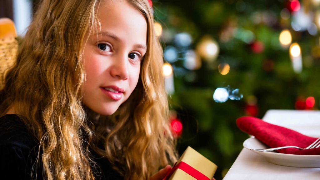 A girl opening a present on Christmas Day at Kingsmills Hotel, Inverness