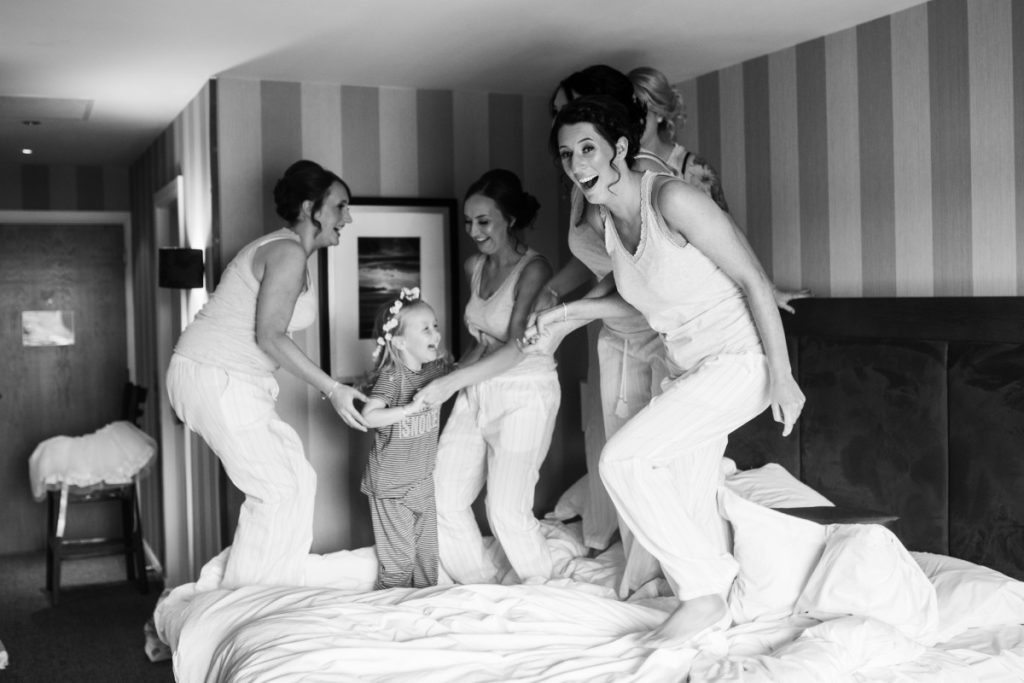 Bridal Party jumping on hotel bed