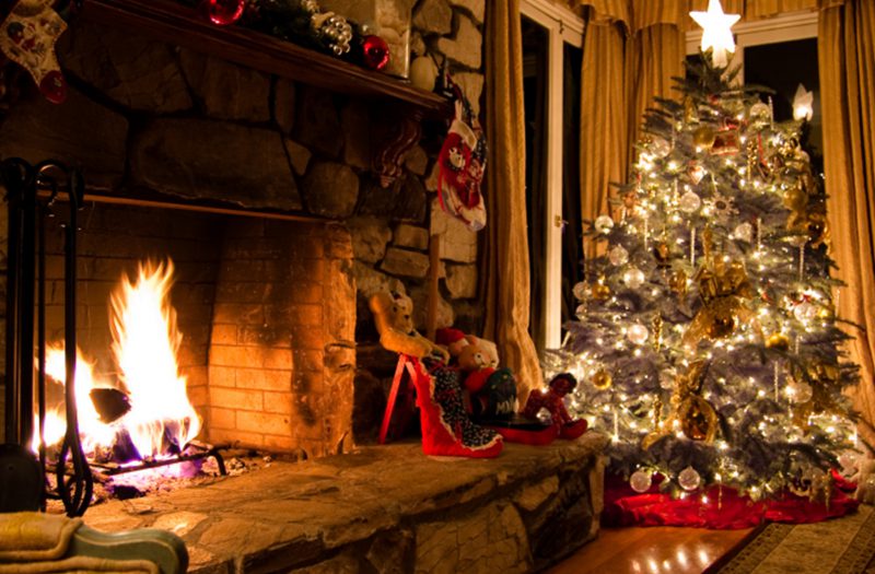A festive winter getaway with Christmas tree and fire.