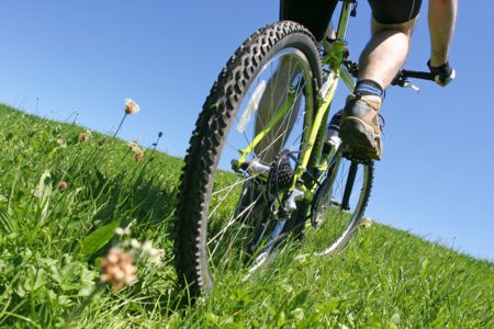 A cyclist climbs a grassy hill near Kingsmills Hotel, Inverness