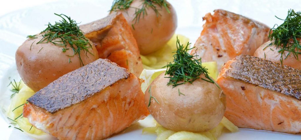 Salmon on a dinner plate with potatoes.