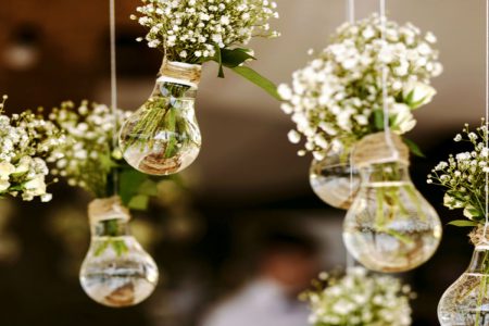 Flowers in old lightbulbs hanging from the ceiling.
