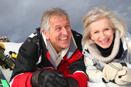An elderly couple enjoying an active ski life