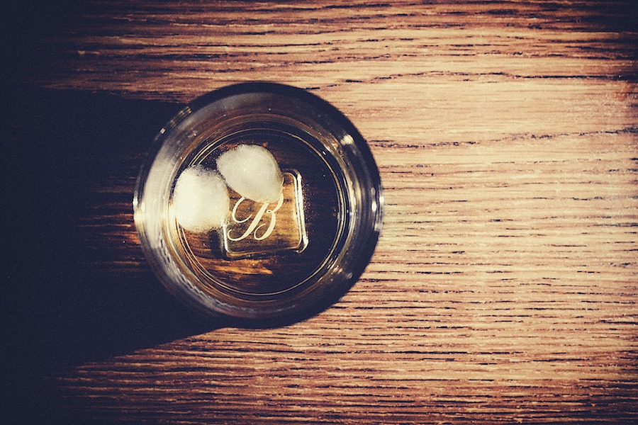 A glass of whisky with two ice cubes, as seen from above.