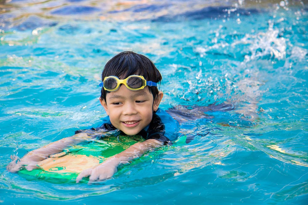 Boy learning to swim in pool