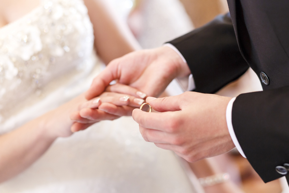 Couple exchanging rings at wedding ceremony