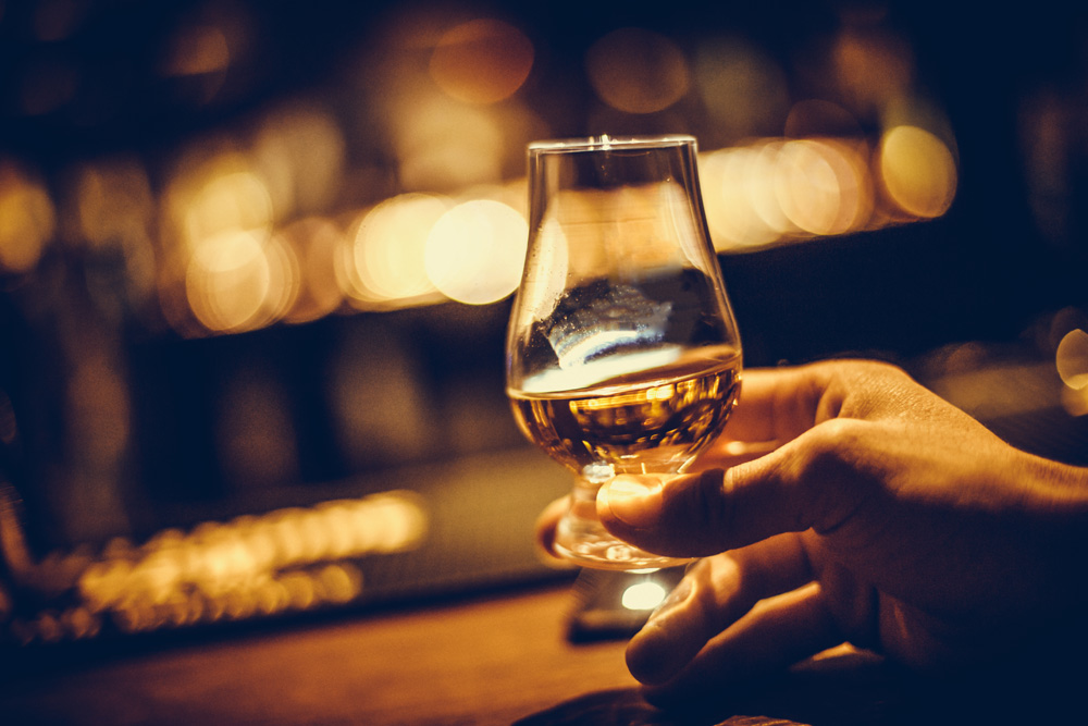 Hand holding a whisky glass