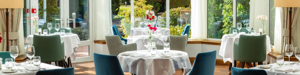 Restaurant filled with natural light and set for dinner service