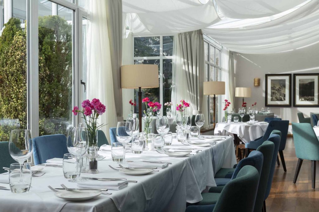 Tables set for dining under the canope in the Conservatory restaurant in the Kingmills Hotel