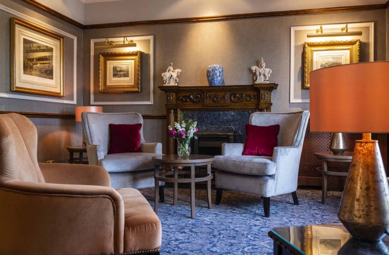 Armchairs by a fireplace in the reception lounge in the Kingmills Hotel