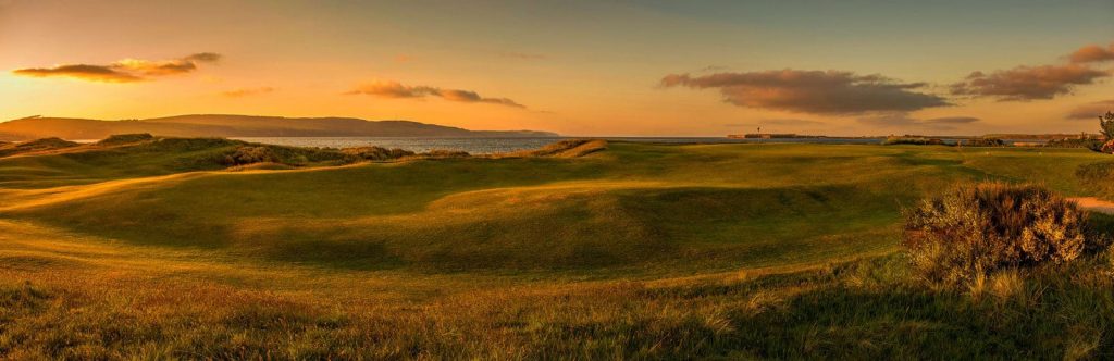 golf green during sunset with hills in background