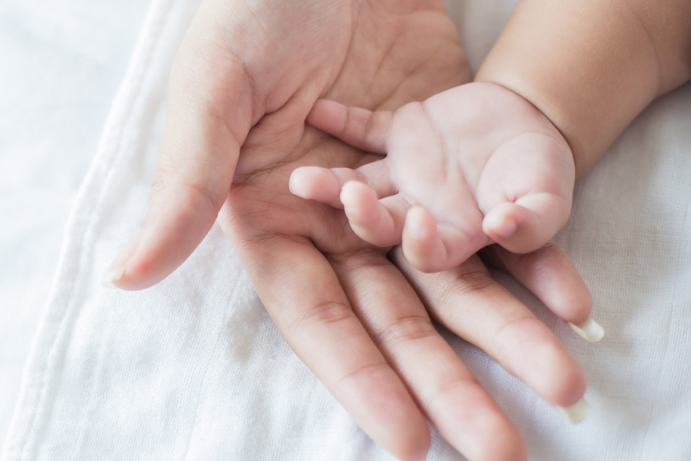 Close up of a baby's hand on a parent's hand