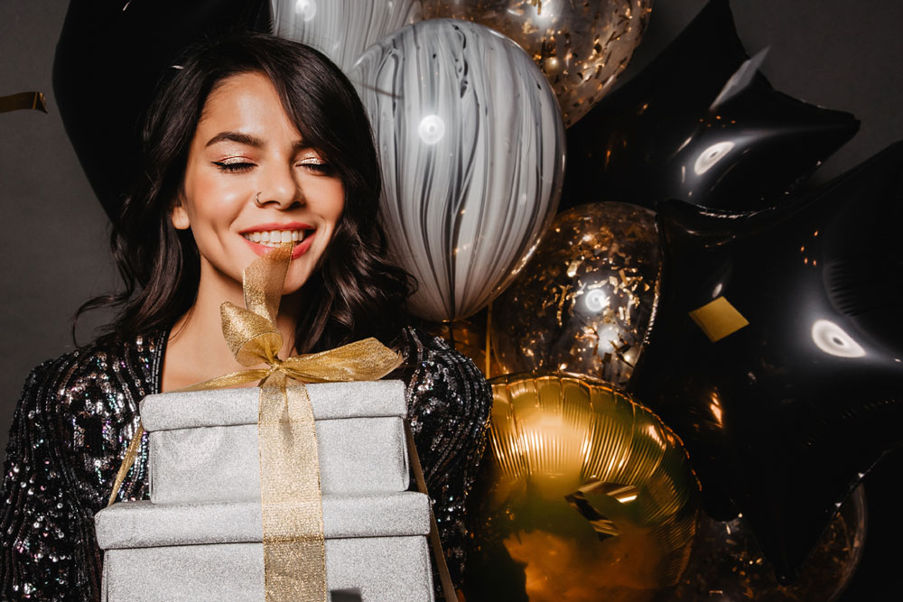 Woman with birthday gifts and balloons