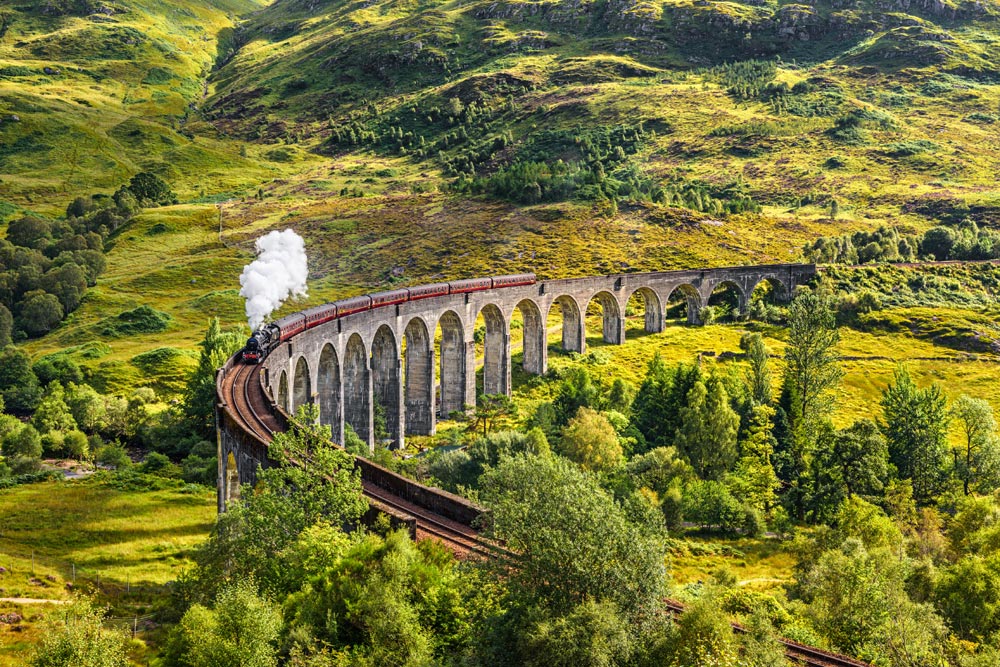 Glenfinnan Railway Viaduct in Scotland with the Jacobite steam train passing over