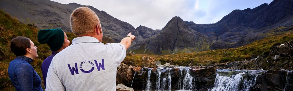 Group of tourists and guide at the Fairy Pools on Isle of Skye