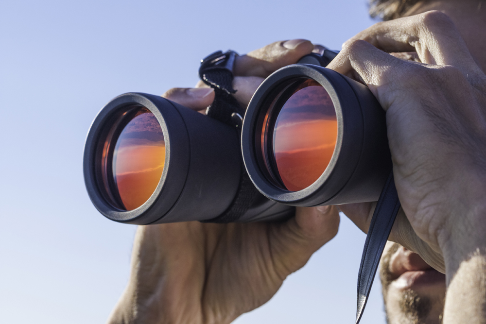 Close up of man looking through binoculars