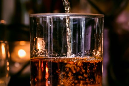 Whisky being poured into a glass at a bar