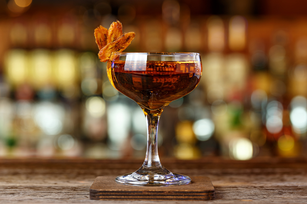 A whisky cocktail sitting on a bar top