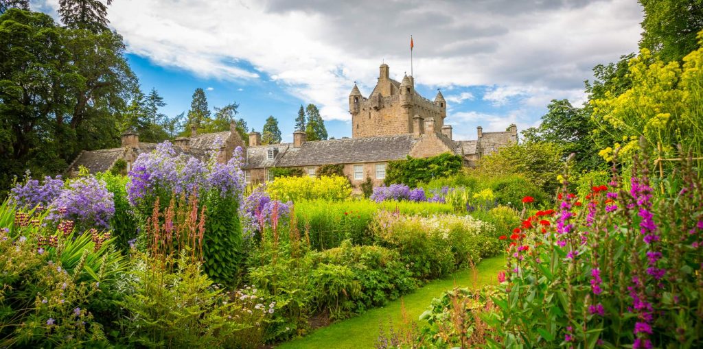 A stunning image of a fairytale castle surrounded by a colourful garden
