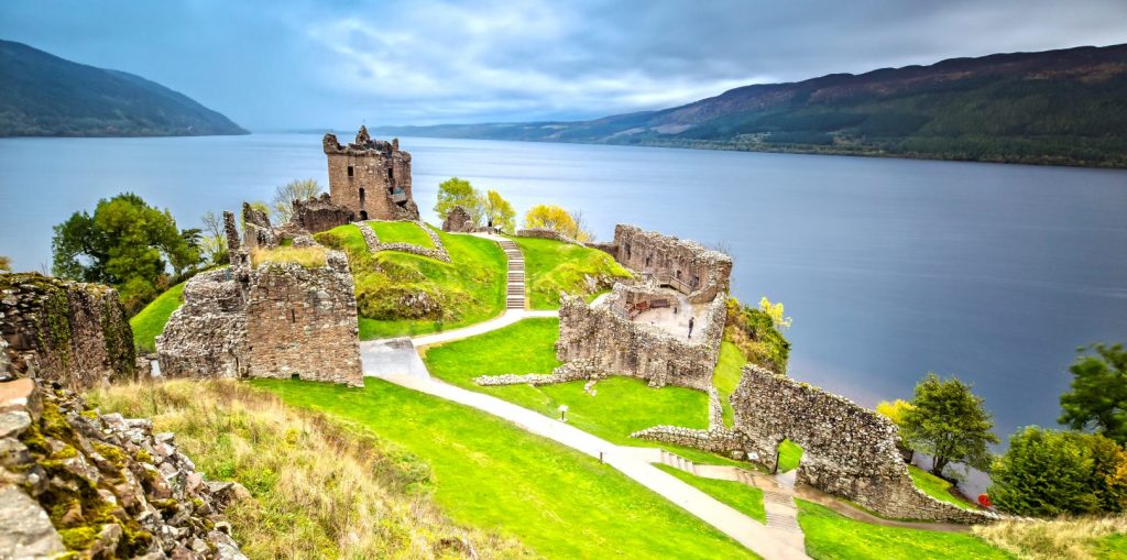 A beautiful image of castle ruins overlooking a Loch.