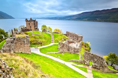 A beautiful image of castle ruins overlooking a Loch.