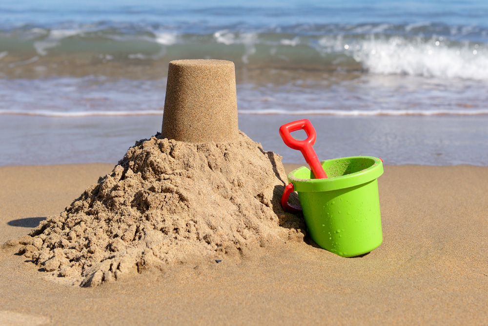 A bucket and spade sitting on the sand