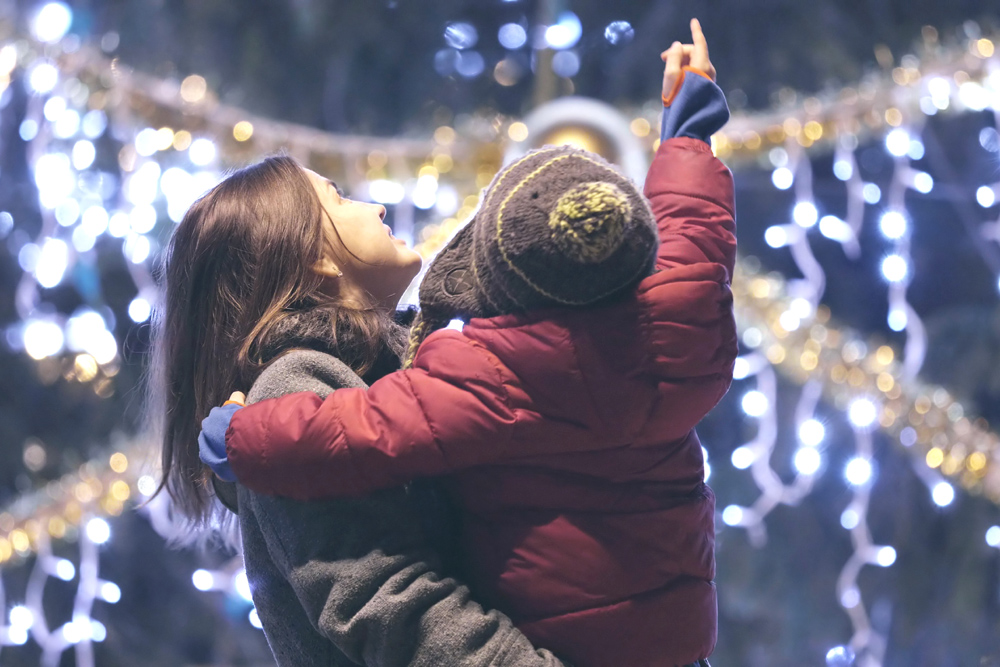 Mother and child looking at festive lights