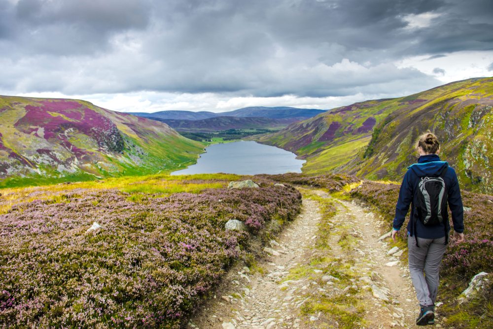 Girl walking to Loch Nagar in the Cairngorms National Park in summer