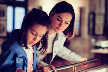 A woman and girl looking at a museum display