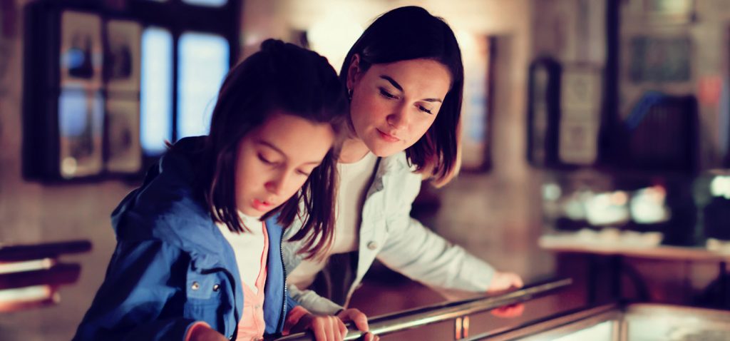 Woman and girl looking at a museum display