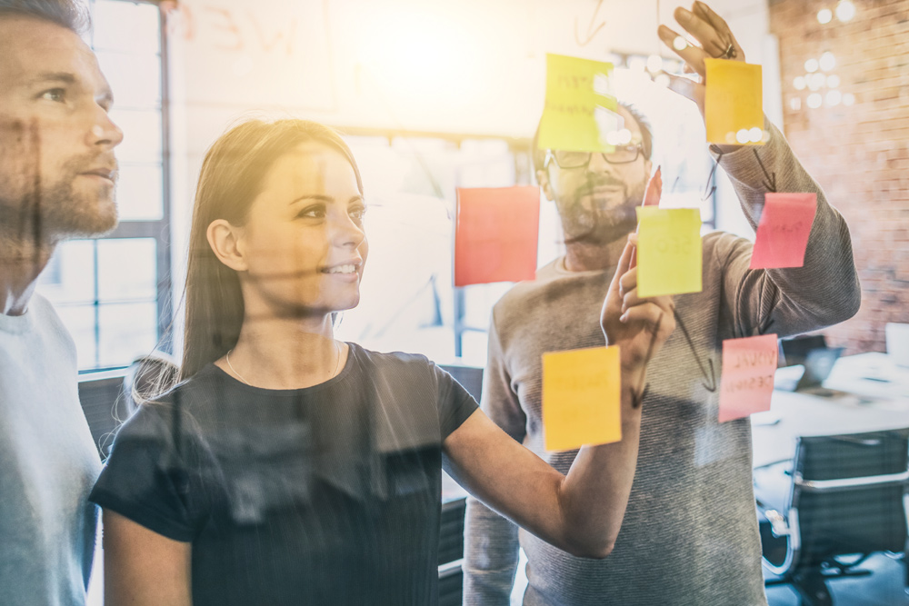 Colleagues sharing ideas on colourful post-it notes