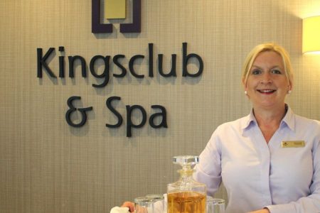 Member of staff with tray at the Kingsclub Reception desk