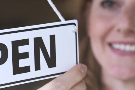 Shop owner turning door sign to open