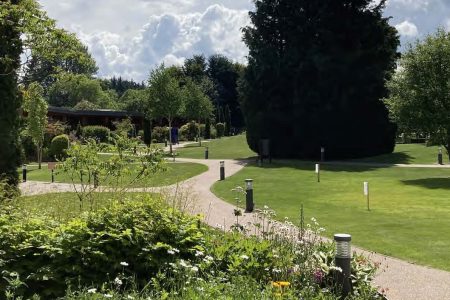 Sprawling lawns, perfect for summer events at The Kingsmills Hotel with flower beds in the foreground and Garden Rooms nestled beyond